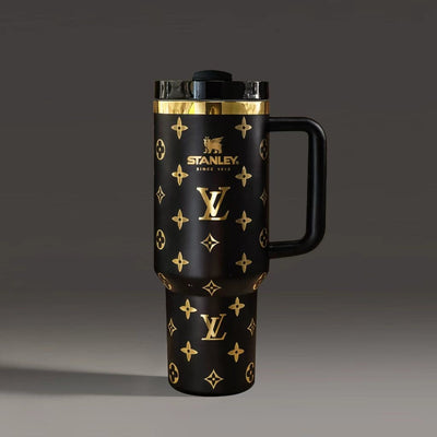 Black travel mug with gold patterns and Stanley logo on a dark background