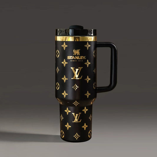 Black travel mug with gold patterns and Stanley logo on a dark background