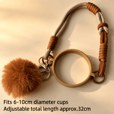 Keychain with brown fluffy pom-pom and adjustable strap on a beige background
