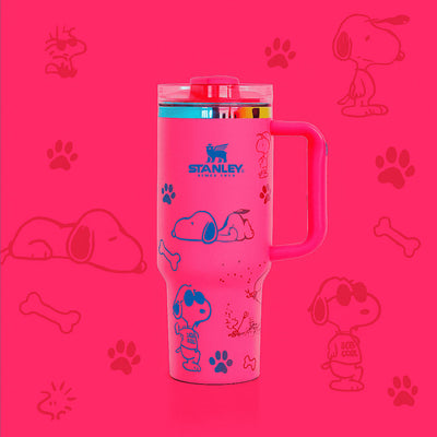 Pink Stanley tumbler with Snoopy illustrations on a pink background with dog-related graphics.