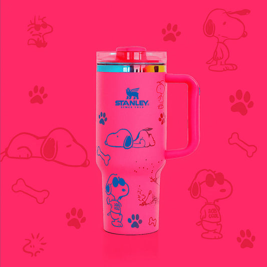 Pink Stanley tumbler with Snoopy illustrations on a pink background with dog-related graphics.