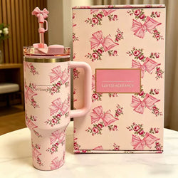 Pink tumbler with floral design and matching box on a neutral background