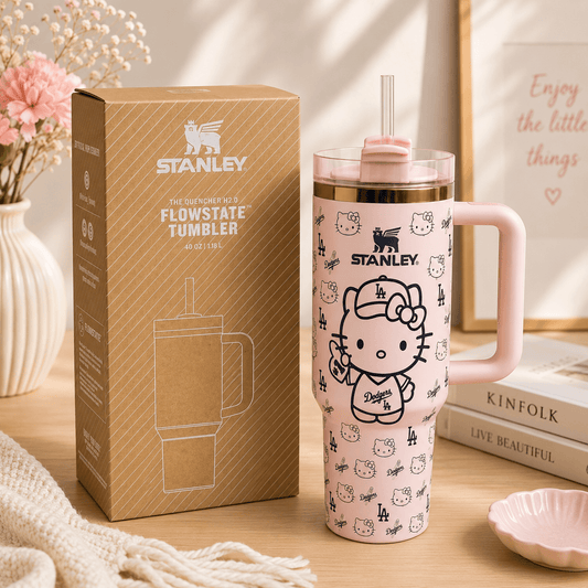 Stanley tumbler with Hello Kitty design next to its packaging on a wooden surface.
