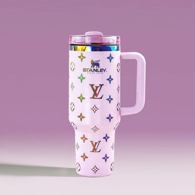 White tumbler with colorful patterns and 'Stanley' branding on a gradient purple background