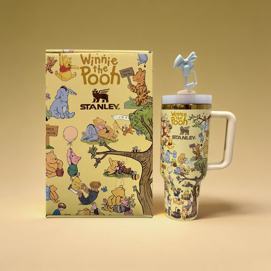 Winnie the Pooh-themed Stanley mug and notebook on a beige background